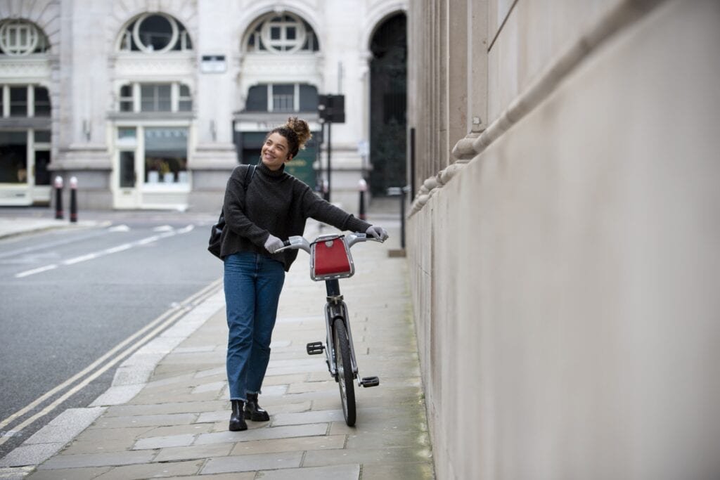 A young woman with a bike going to work