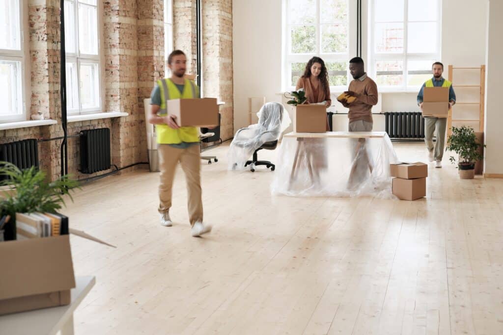 Professional office movers and the moving committee emptying an office space during the moving day