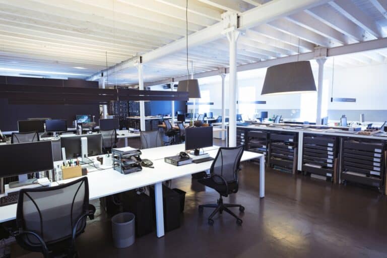 A spacious office with several desk, computers, chairs, and other office items in the concept of 'How to Pack Equipment and Furniture'.